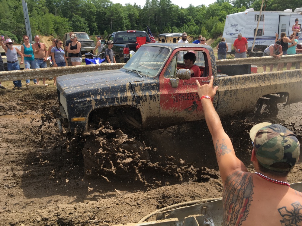 Spectators cheer as a pickup truck splashes through mud at an event formerly called the Redneck Olympics on Saturday in Hebron. The organizer now calls the event the "Redneck (Blank)" after Olympic officials complained about the name.
