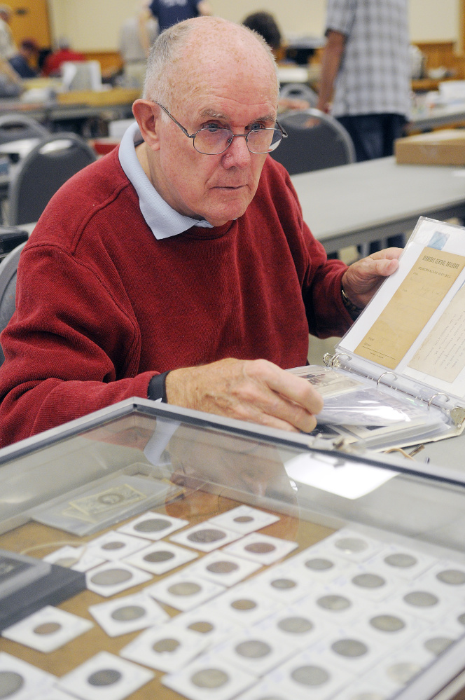 Frank Trask, of Farmingdale, assesses a collection Sunday at the Capital City Coin Show, held at the Elks Lodge in Augusta.