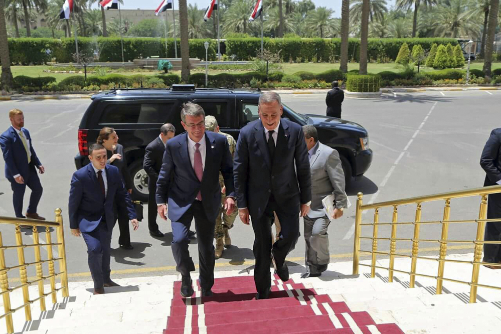 Visiting U.S. Defense Secretary Ash Carter, center left, accompanied by the Iraqi Defense Minister Khaled al-Obeidi, center right, arrives to the Ministry of Defense in Baghdad, Iraq. As Carter arrived in Iraq, Monday, he said U.S. and coalition forces will use the newly retaken air base in Qayara as a staging hub as Iraqi security forces move closer to the long-awaited battle to recapture Mosul from Islamic State militants.