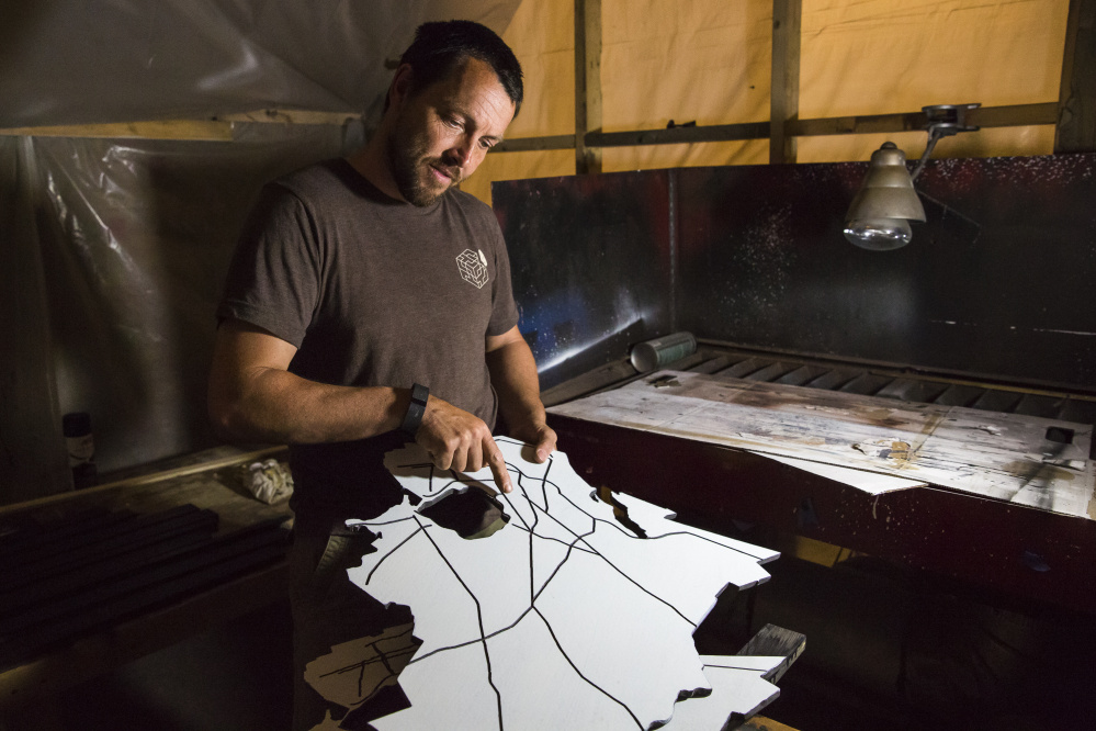 Craftsman Jake Ryan talks about the tabletop in the shape of Portland he's working on at his industrial workshop on Thompson's Point. "It's the beginning of civic engagement," he said.