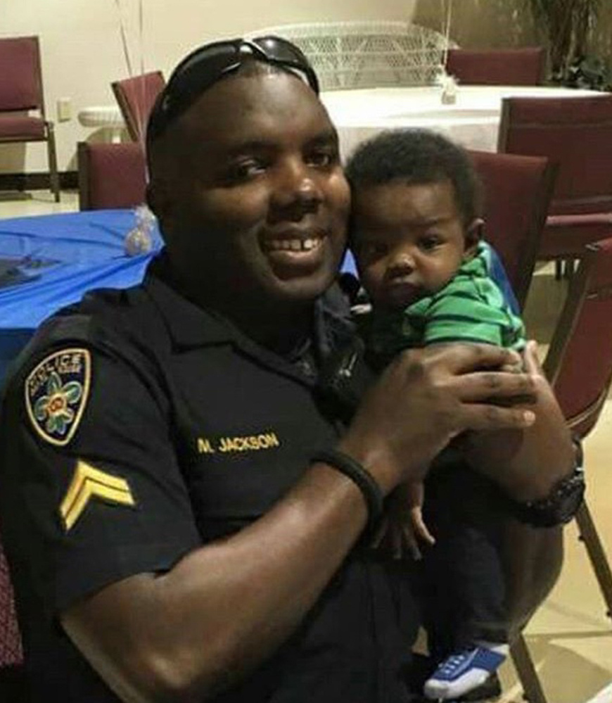 Police Officer Montrell Jackson holds his son, Mason, at a Father's Day event for police officers in Baton Rouge, La.