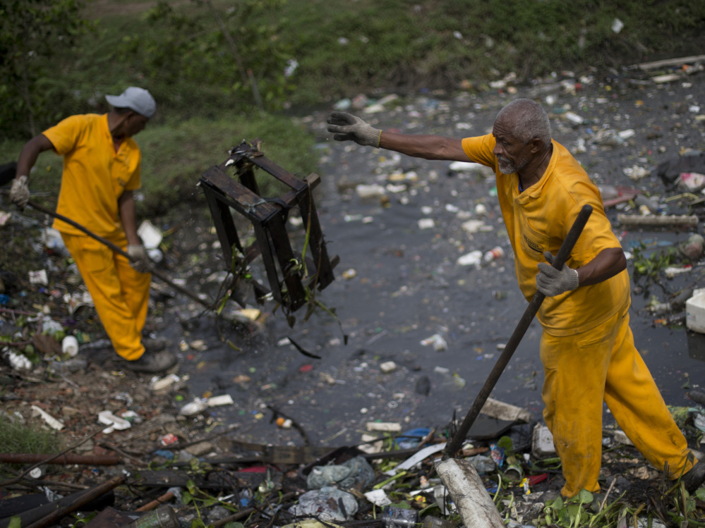 Brazilian sanitation workers remove garbage collected by floating waste barriers in the Meriti River, which flows into Guanabara Bay, where sailing races are scheduled to be held at next month's Summer Games in Rio de Janeiro.
Associated Press/Silvia Izquierdo
