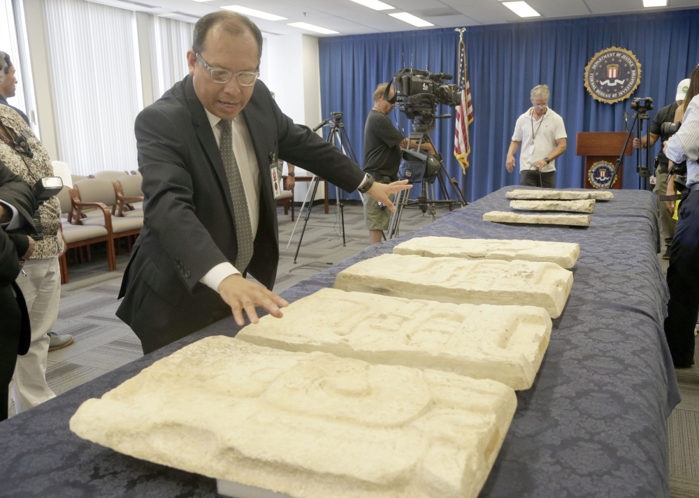 Los Angeles-based Consul General of Guatemala Roberto Archila reviews pre-Columbian Mayan artifacts during a repatriation ceremony at FBI offices Friday in Los Angeles.