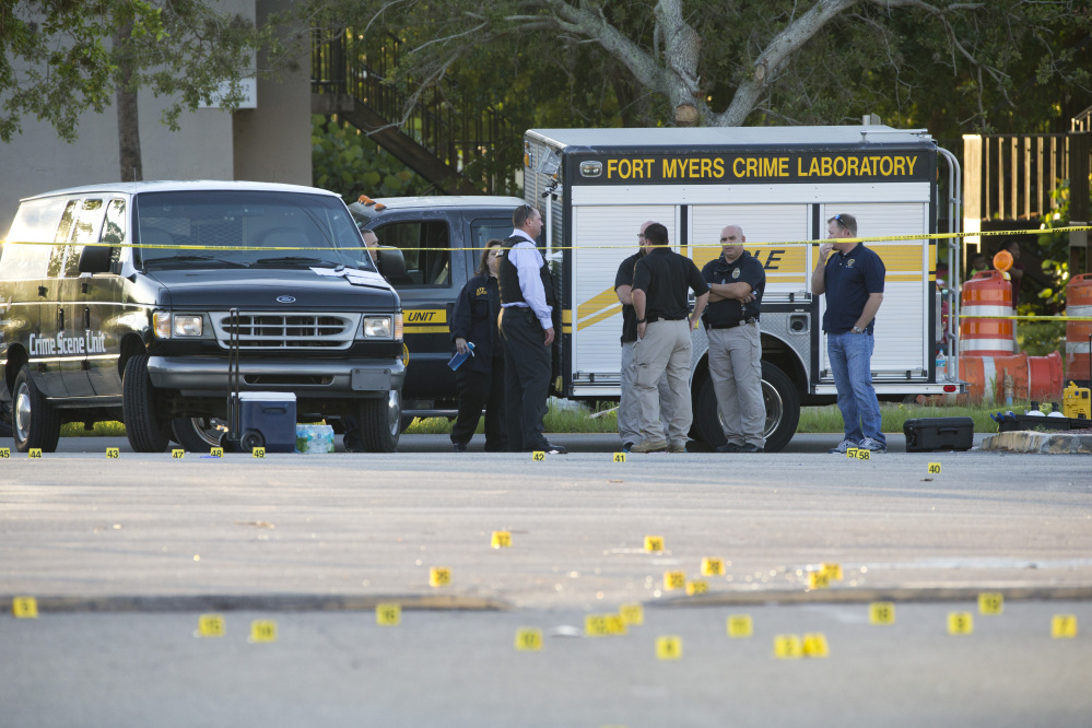 A Fort Myers Crime Laboratory vehicle and yellow evidence markers are at the scene of a deadly shooting outside of Club Blu in Fort Myers, Fla., on Monday.