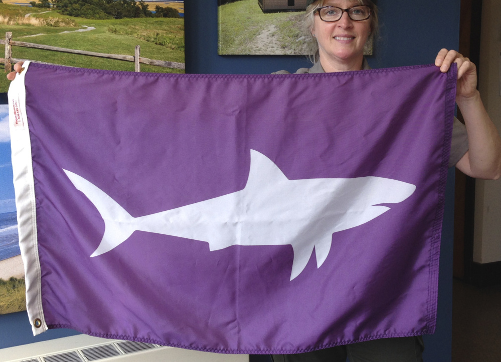 Leslie Reynolds, chief ranger at the Cape Cod National Seashore, displays a shark-alert flag in May at the National Park Service's Cape Cod headquarters in Wellfleet, Mass. The flags warn beachgoers to avoid the water where sharks have been sighted.