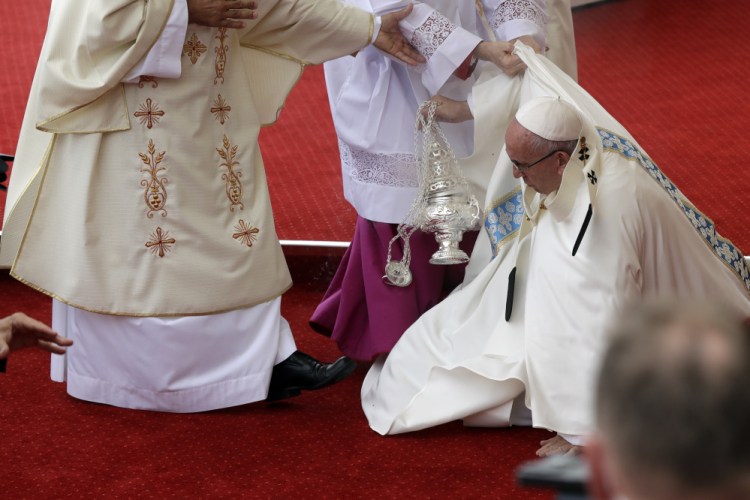 Pope Francis is helped by Vatican Master of Ceremonies, Mons. Guido Marini as he stumbles on the altar as he celebrates a mass in Czestochowa, Poland.
