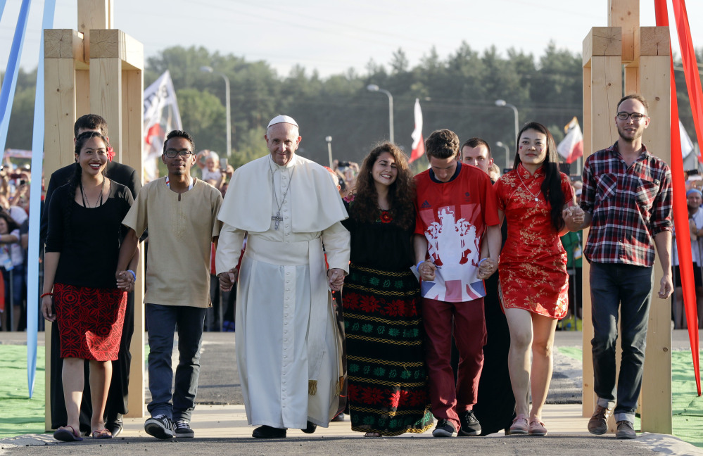 Pope Francis, accompanied by youths, passes through the Door of Mercy ahead of a prayer vigil on the occasion of World Youth Day, in Campus Misericordiae in Brzegi, near Krakow, Poland, on Saturday.
