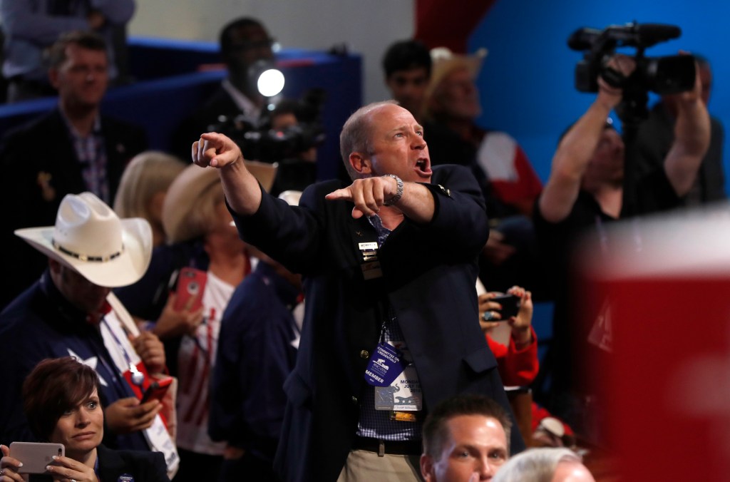 A delegate shouts as a call for a roll call vote on the rules goes out Monday, the opening day of the Republican National Convention in Cleveland.