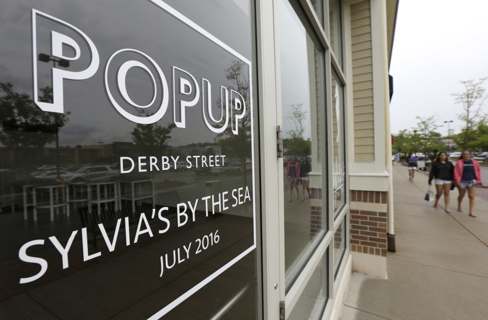People walk past the entrance of a pop-up store location at the Derby Street Shoppes outdoor mall in Hingham, Mass., on Tuesday. Entrepreneurs increasingly are taking the "pop-up" concept in new directions.