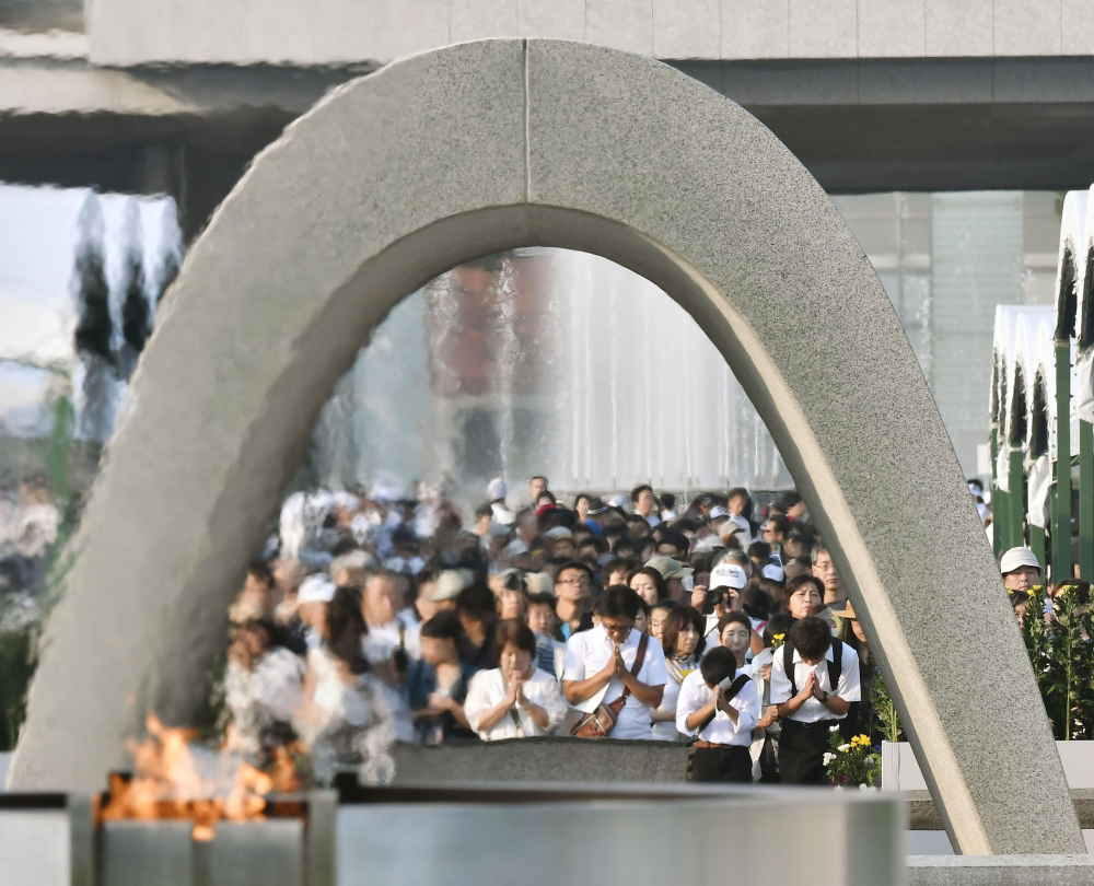People pray for the atomic bomb victims in front of the cenotaph at the Hiroshima Peace Memorial Park in Hiroshima on the 71st anniversary of the bombing Saturday.