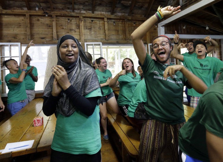 Teenagers celebrate victory in a competition at the Seeds of Peace camp in Otisfield on Friday. The lakeside camp in the woods of Maine has embarked on a pilot program this summer with teenagers from Los Angeles, Chicago and New York.