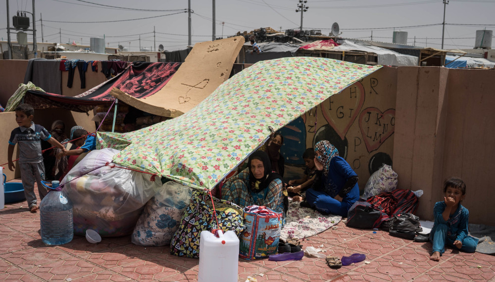 Iraqis rest under an improvised tent in a yard where they have been sleeping at the Dibaga camp for displaced civilians. As many as 3,000 people have arrived here in the last week.