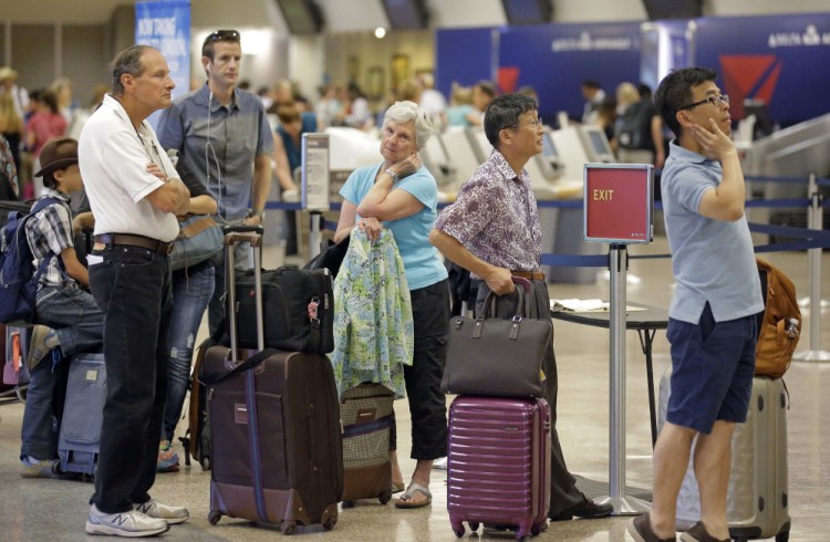 Passengers stand in line Tuesday in Salt Lake City as Delta Air Lines slogged through a second day of its recovery from a global computer outage. Portland's jetport also reported canceled and delayed Delta flights Tuesday.