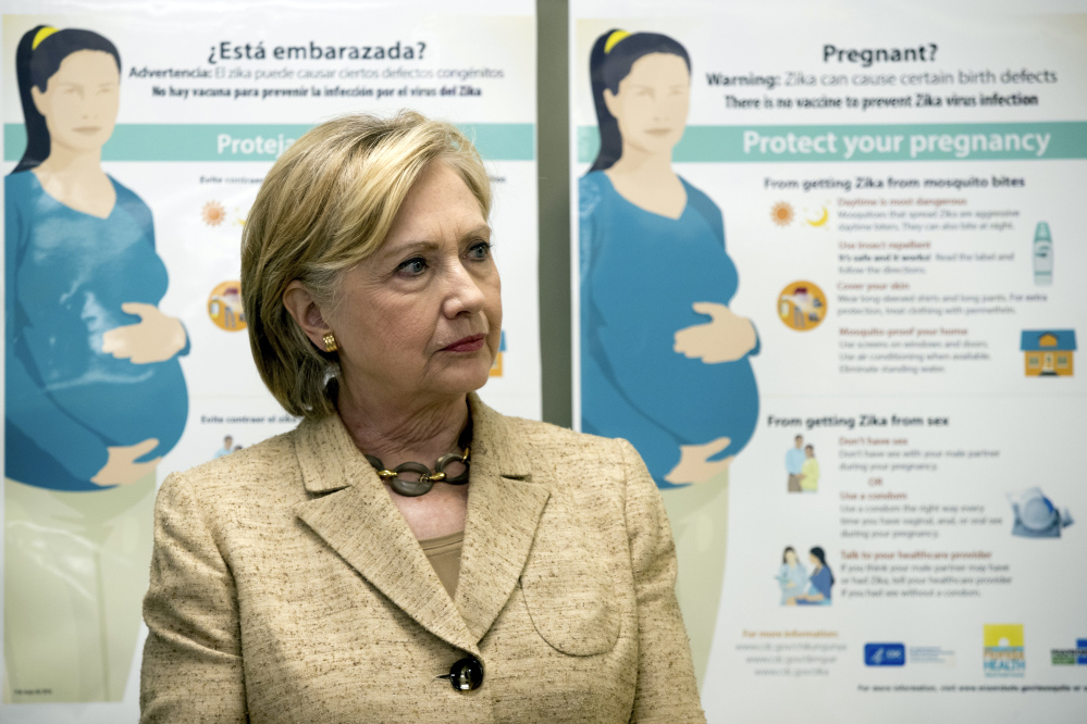 Informational Zika posters for pregnant woman are displayed behind Democratic presidential candidate Hillary Clinton at Borinquen Health Care Center on Tuesday in Miami, where she called for Congress to put resources into fighting the Zika virus.