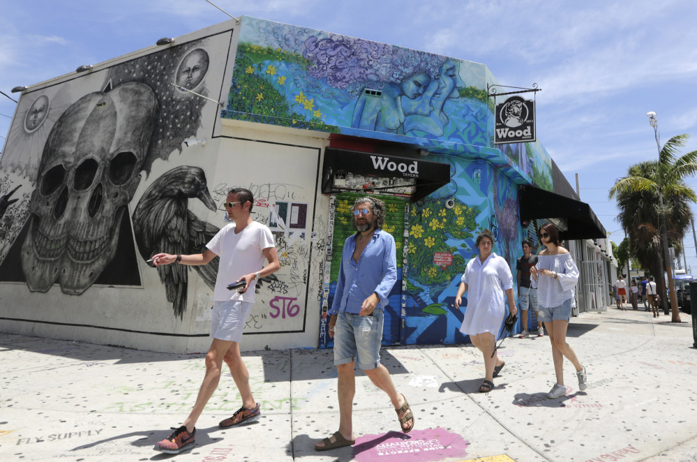 Visitors stroll through the Wynwood area Friday in Miami. Florida now reports 21 people have contracted the Zika virus in a 1-square-mile area encompassing Wynwood.