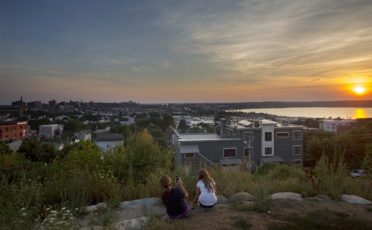 Nicole Hoglund of Portland, left, watches the sunset with her niece Sophia Lanzano of New Jersey on Thursday from Fort Sumner Park in Portland. The top floor of a proposed condominium complex would obscure this view of Back Cove.