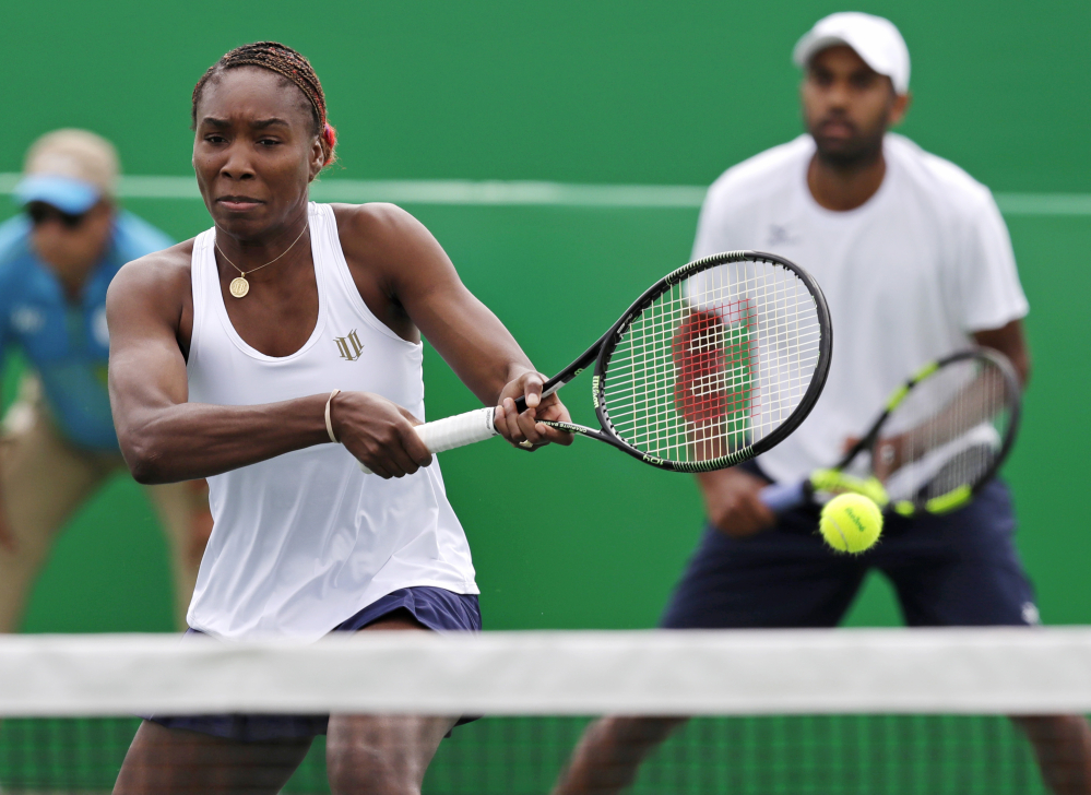 Venus Williams, seen playing with Rajeev Ram in Thursday's mixed doubles match against the Netherlands, reached the semifinals Friday in a win over Italy.