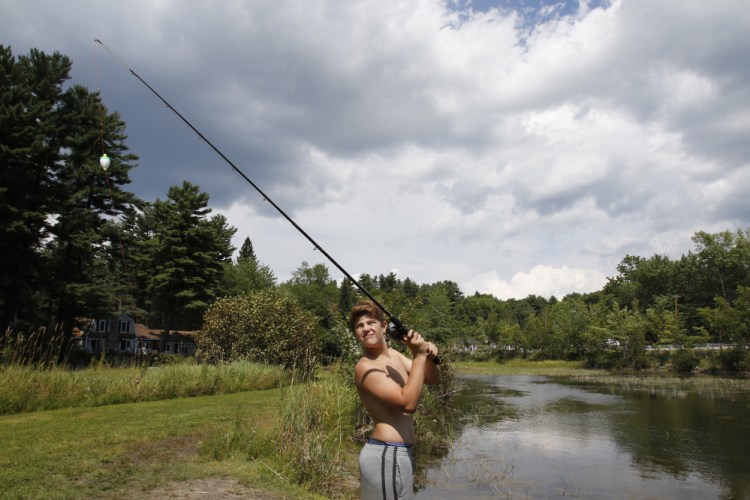 Brady Roux, 13, of Salem, N.H., prepares to cast Friday along an inlet off Jordan Bay on Sebago Lake in Raymond. State biologists are urging anglers to quickly catch and release fish that are stressed by warm water and low water levels.