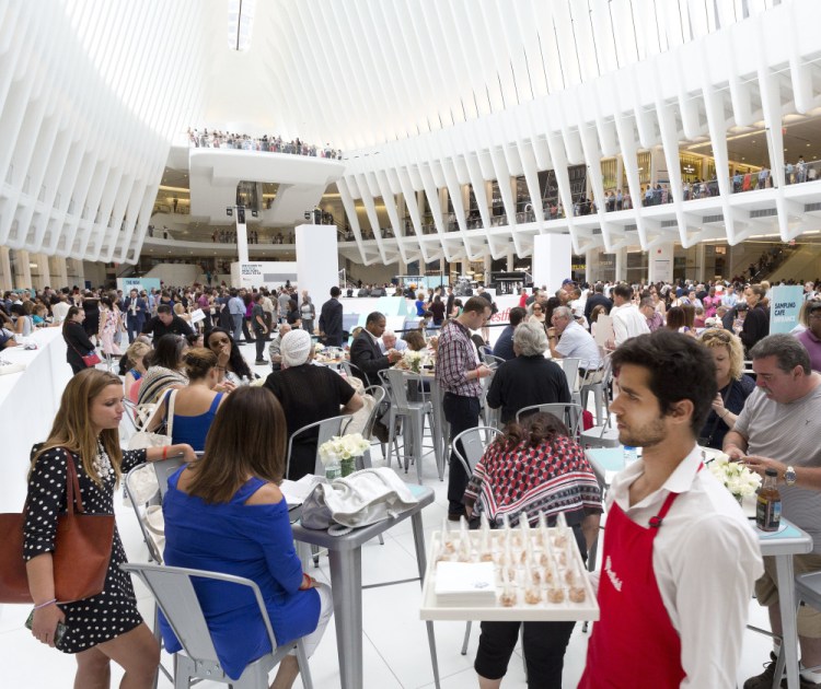 A waiter carries a tray in the World Trade Center Transportation Hub on Tuesday in New York as the new – and reinvented – mall there opens. A wide variety shops and restaurants serve the needs of a much larger and more diverse clientele.