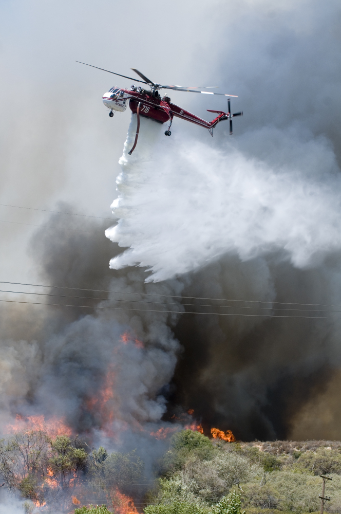 A helicopter makes a water drop on a wildfire as it burns near Cleghorn Road in the Cajon Pass in California. The fire forced the shutdown of a section of Interstate 15, the main highway between Los Angeles and Las Vegas, leaving commuters stranded for hours.