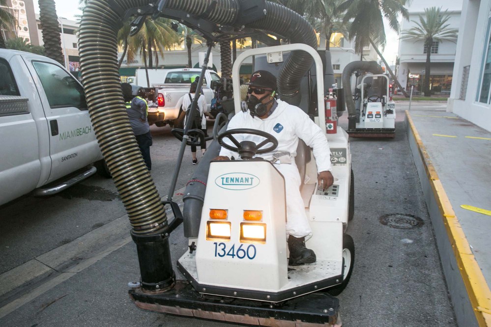 A City of Miami Beach Sanitation worker gets ready to clean the alleyways of South Beach, sucking up still waters and debris with a mobile vacuum, Friday, Aug. 19, 2016, Miami Beach, Fla., as part of the city's Zika prevention clean-up programs.