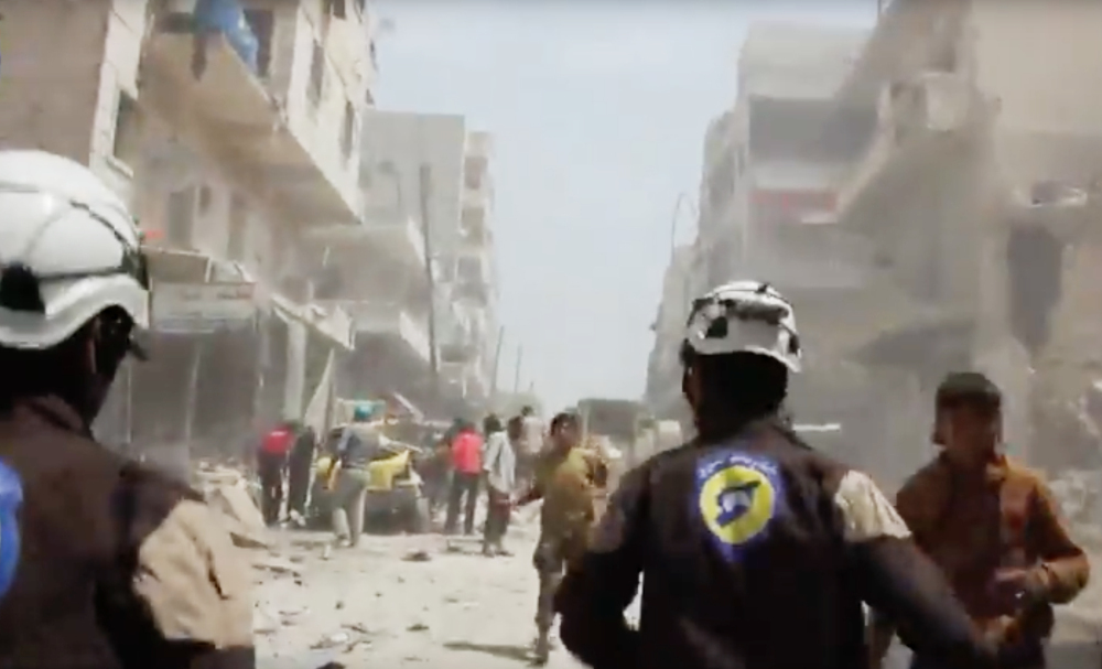 Civil defense workers , also known as the White Helmets, run to help the injured after airstrikes and shelling in Aleppo, Syria, in April. 