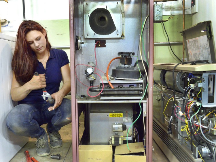 Sara Myers works on the piping of a gas furnace she's assembling at the Technical Education Center in Brunswick. Myers, 22, was working at a day care facility when she decided to enroll. She graduates in two weeks and already has job interviews lined up.