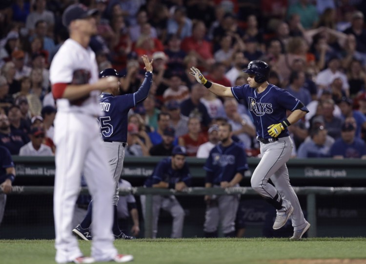 Tampa Bay's' Evan Longoria  is congratulated by third base coach Charlie Montoyo after his solo home run off Red Sox pitcher Clay Buchholz during the eighth inning.   Associated Press/Charles Krupa