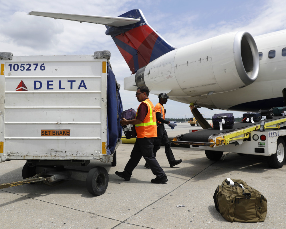 Airport workers unload baggage at Baltimore-Washington International in Linthicum, Md. Delta plans to have its new baggage system online in 344 airports by Sept. 1.