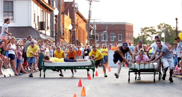 Two teams compete in a bed race down Russell Street in downtown Skowhegan during the Moonlite Madness festival during a past River Fest. This year's River Fest, with aims to promote the use of the Kennebec River and help raise money for the Run of the River water park, begins Tuesday and lasts through Saturday.