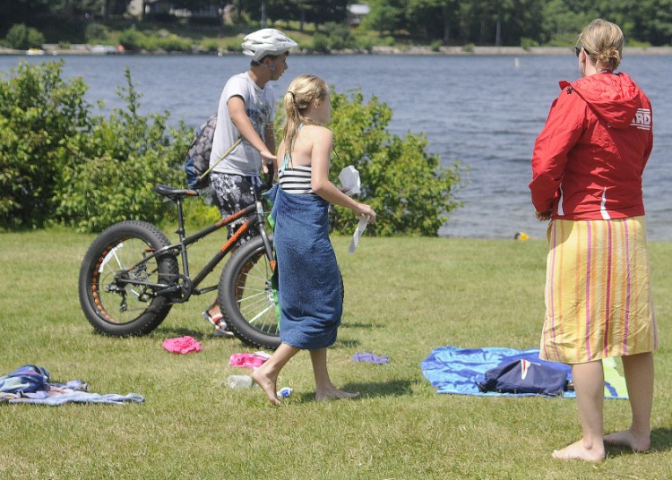 Lifeguard Elizabeth Preble, right, speaks to visitors July 20 at the town beach on Maranacook Lake in Winthrop. The Town Council voted Monday night to spend money on a bike patrol at the beach and in the downtown area for the rest of summer to address concerns about vandalism and other disturbances.