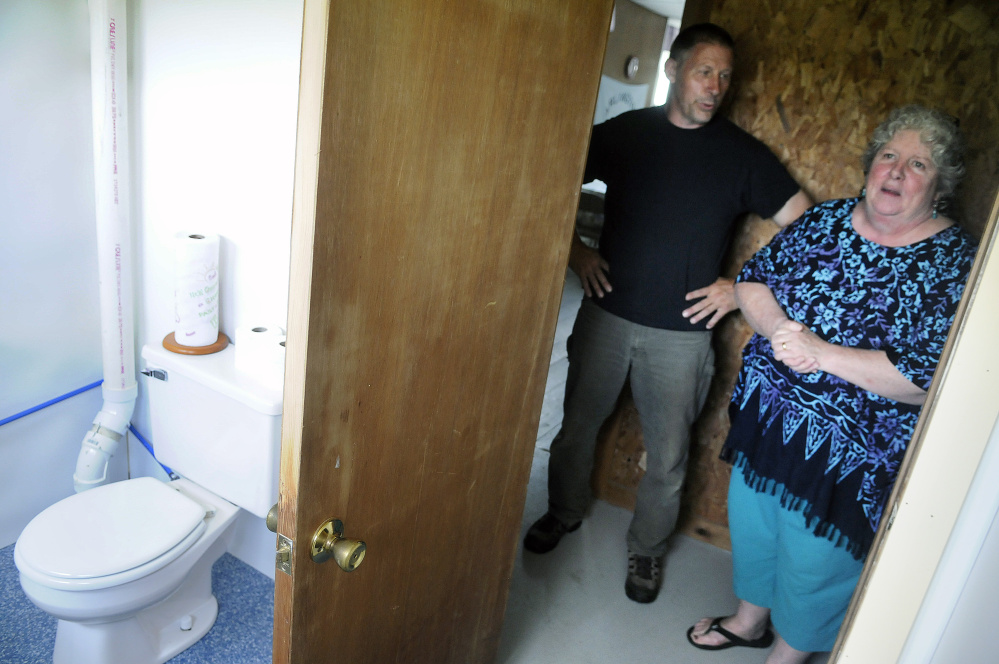 Dana and Debbie Rogers show off the new flushing toilet Tuesday at the Arlington Grange in Whitefield.