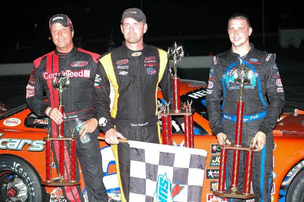 Mike Landry, left, stands with Wayne Helliwell Jr., center, and Joey Polewarczyk on the podium Sunday at Oxford Plains Speedway. Landry finished a career-best third in the H.P. Hood 150.