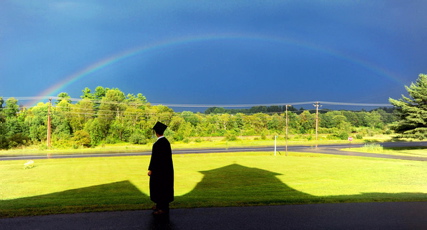 Cody Buzzell, 17, stands in the shadow of Moody Chapel as a rainbow shines over Hinckley before the 2013 Maine Academy of Natural Sciences at Good Will-Hinckley commencement. The school holds its fifth commencement Saturday.