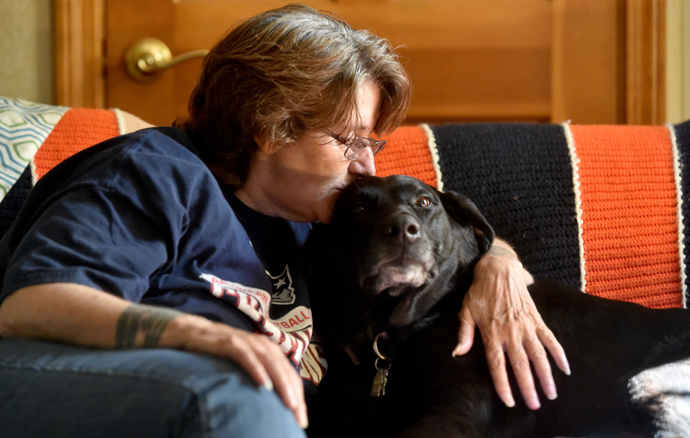 Eva St. Jean is comforted by her dog, Jasmine, as she talks about the struggle to find housing in Waterville that will allow her to live with the 80-pound black Lab mix. Pet owners say the city isn't pet-friendly to those looking for rental housing. St. Jean is staying with a friend in Clinton as she looks for somewhere to live.