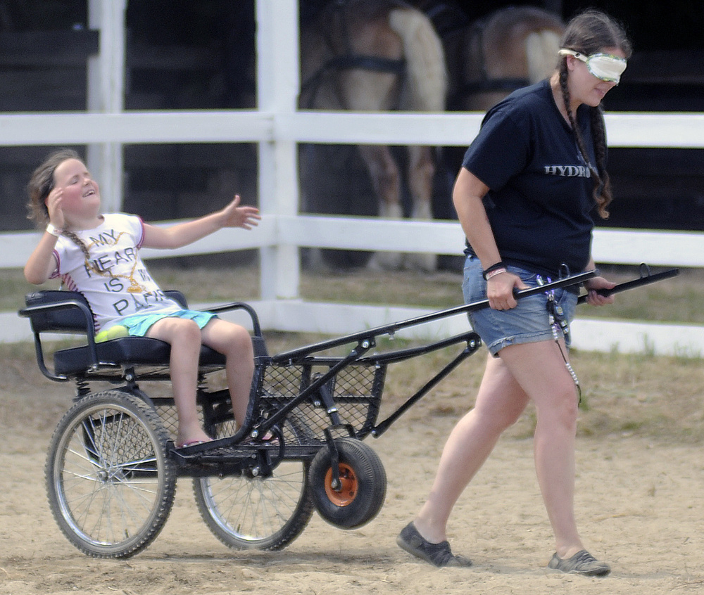 Meka Morrison, 7, reacts to being a little off course while being towed by her mother, Jennifer Morrison, during the Back Seat Driver Contest at the Monmouth Fair on Sunday.