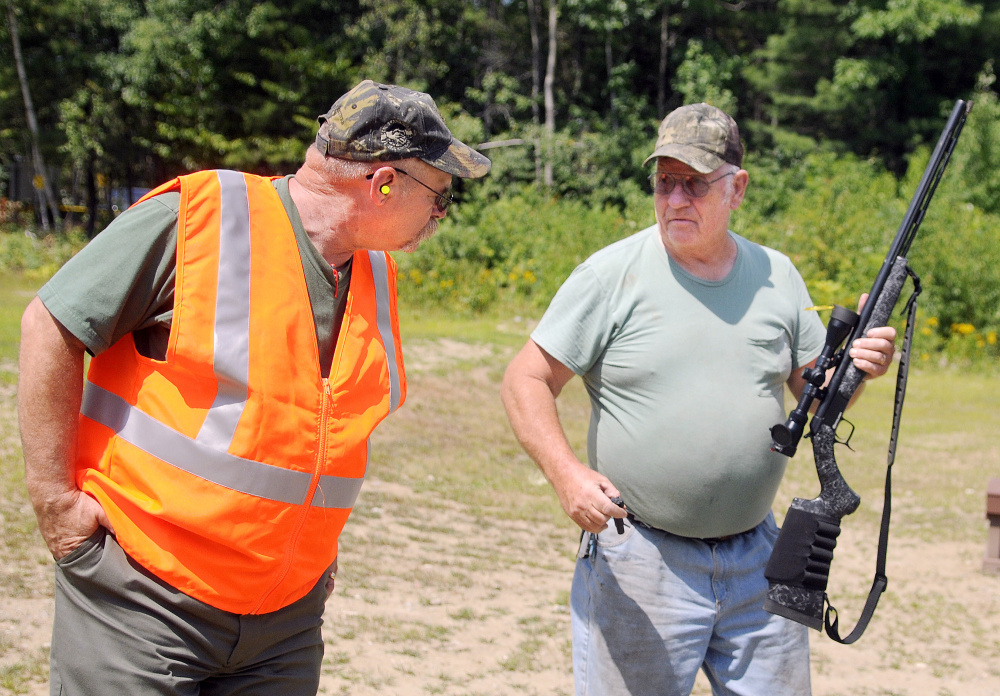 Craig Gerry, range grant coordinator for the Department of Inland Fisheries and Wildlife, right, examines a black powder gun that Dick Salmonson, of Vassalboro, fired Thursday at the IF&W range in Augusta.