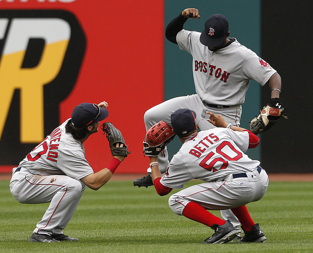 Boston outfielders, from left, Andrew Benintendi, Mookie Betts and Jackie Bradley Jr. celebrate a 3-2 win against the Indians on Monday.