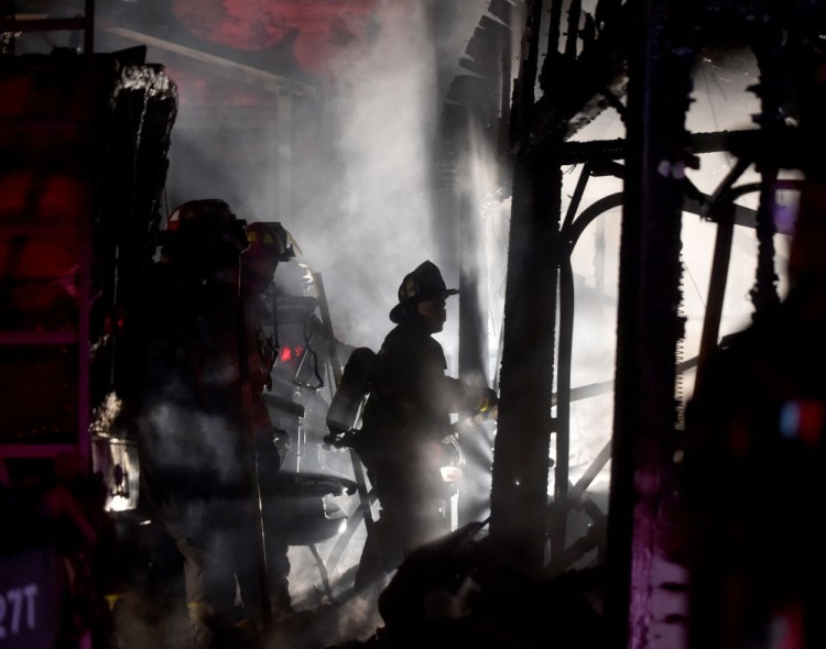 Waterville firefighters battle a Belmont Avenue fire last Wednesday. Investigators said Monday that the fire, which destroyed a garage and several vehicles, was found to have been set intentionally.