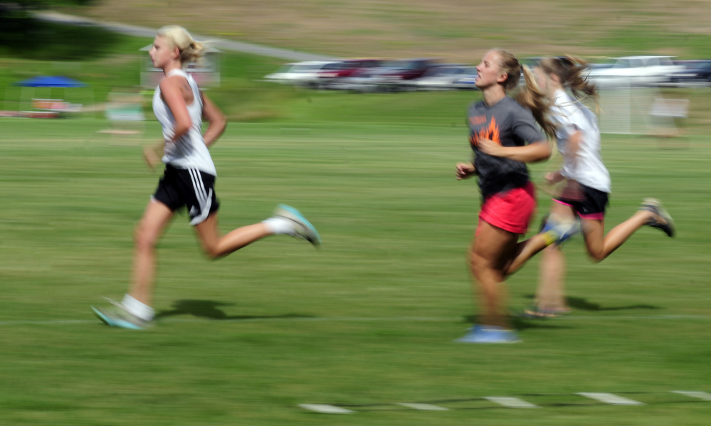 Monmouth Academy girls soccer players run laps around the field at the end of practice Tuesday morning in Monmouth.