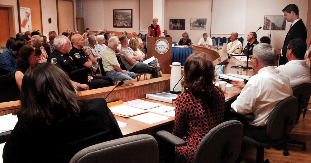 Waterville resident Jessica Laliberte, center, expresses her opinions on the municipal and school budgets before the city council, Mayor Nick Isgro, standing, and other residents and city officials on Tuesday.