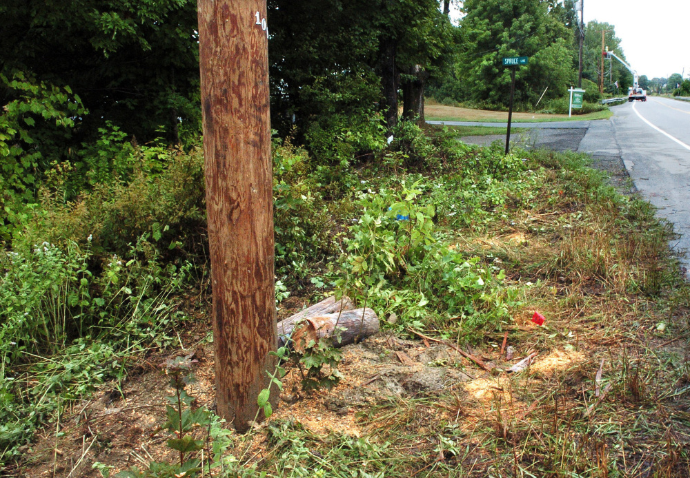 A utility pole on U.S. Route 202 in Unity, foreground, was snapped in half when it was hit by a pickup truck Tuesday night. A utility worker, background, repairs a second pole that he said was also affected by the crash. Harold Fickett III, of Clifton, was killed and the driver and another passenger were injured.
