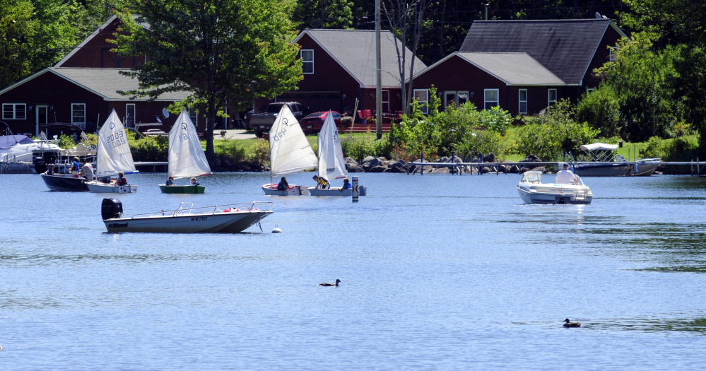Boats go through the channel on Friday in Mill Stream in Belgrade Lakes.