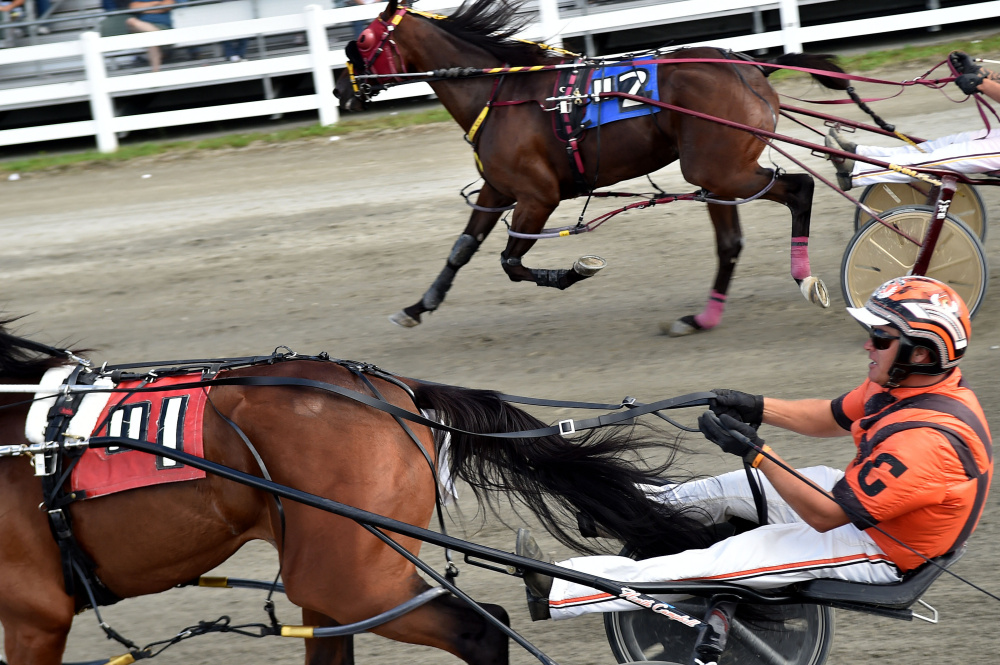Heath Campbell, bottom, races Bet You (#1) to beat Ron Cushing, racing Escape The News (#2), in a photo finish to win the Walter H. Hight Memorial Pace at the Skowhegan Fairgrounds in  Skowhegan on Saturday.