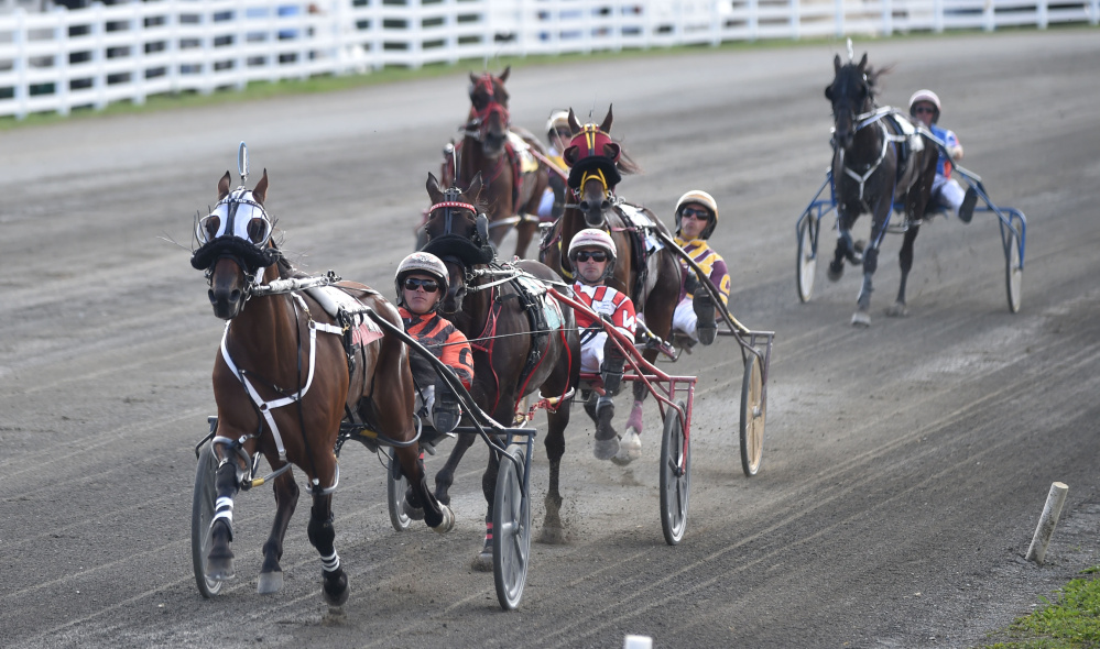 Horses race down the track in the first half mile of the Walter H. Hight Memorial Pace at the Skowhegan Fairgrounds in Skowhegan on Saturday.