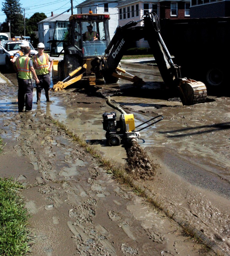 Silty water is pumped from a large hole in Clinton Avenue in Winslow after a water main break on Sunday. The roadway was flooded and traffic was detoured around the scene as crews from Kennebec Water District made repairs.