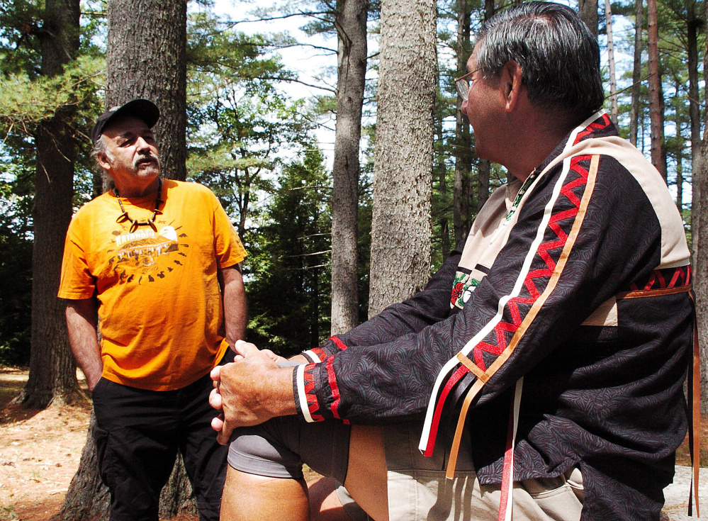 Abnaki tribe member Tom Obomsawin, left, and Penobscot tribe elder Butch Phillips speak Sunday about Native American culture prior to a ceremony honoring ancestors and tribe members that were massacred in 1724 in The Pines area off the Father Rasle Road in Madison.