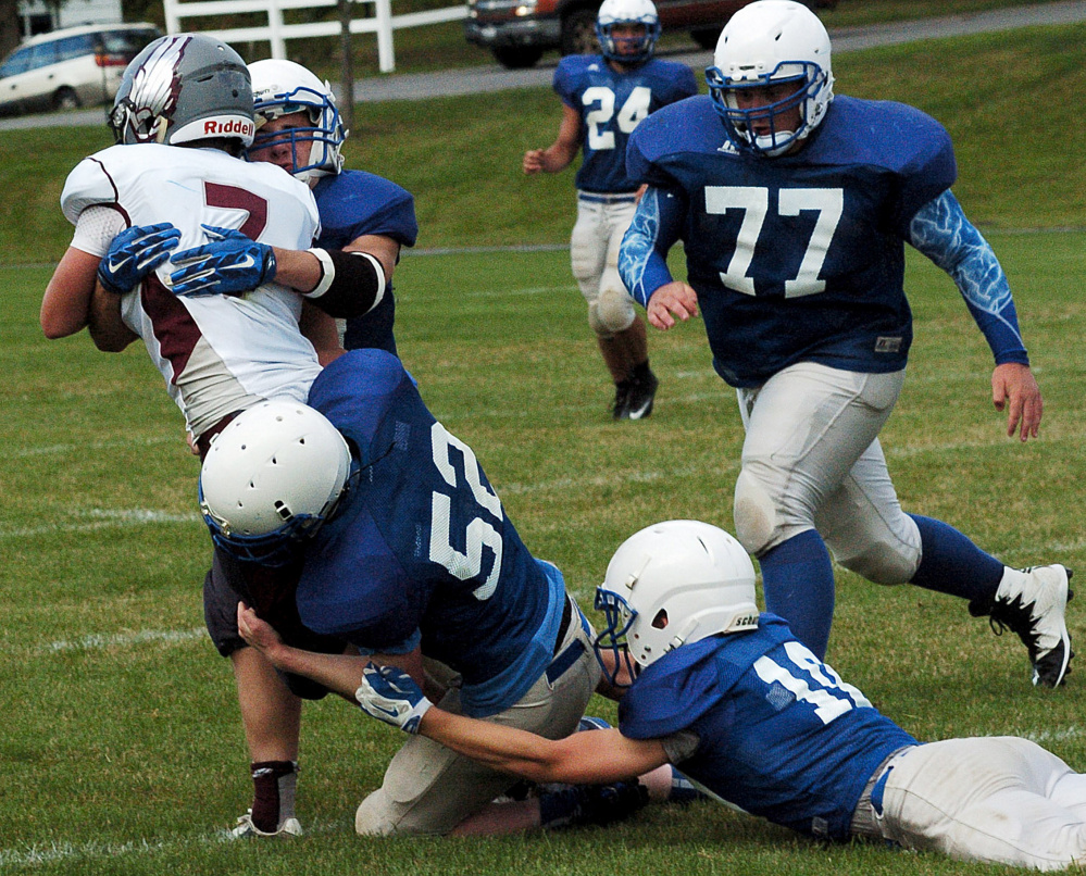 Madison football players gang up and tackle a ball carrier during a scrimmage in Pittsfield on Monday.