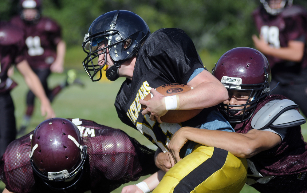 A Maranacook ball carrier gets tackled by a Nokomis defender during a scrimmage Monday afternoon in Readfield.