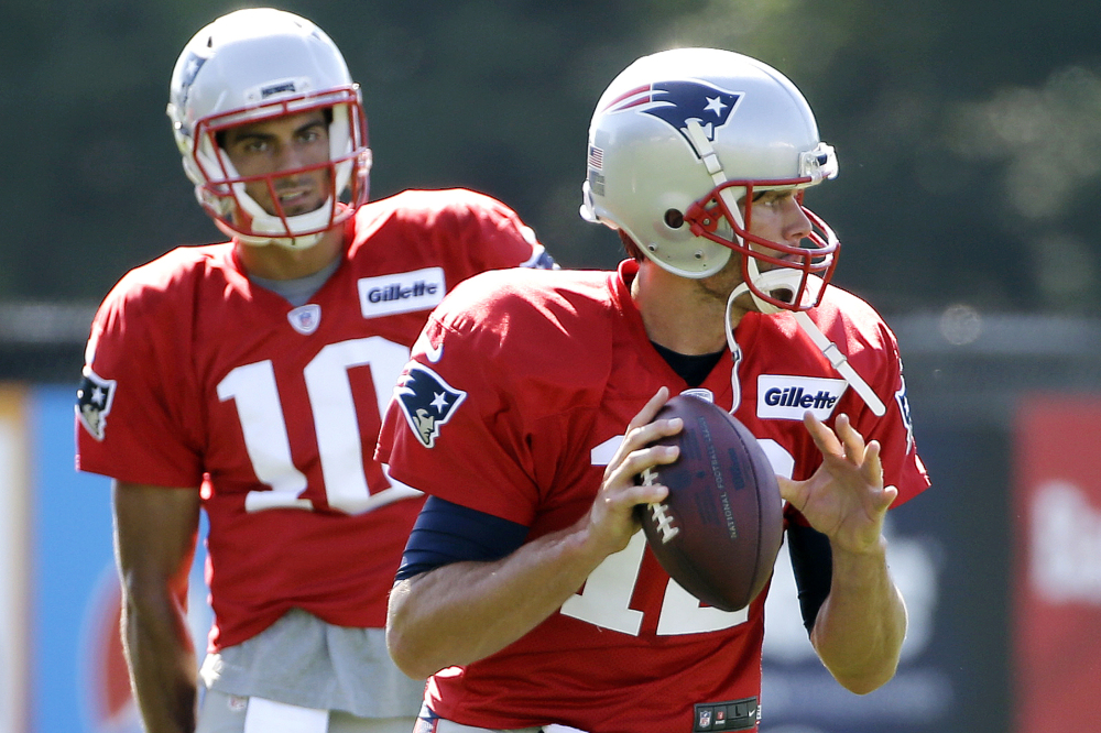 New England quarterback Tom Brady gets set to throw a pass as quarterback Jimmy Garoppolo watches during an Aug. 9 practice in Foxborough, Massachusetts. Brady says he's ready to play after a "silly accident" cut his right thumb with a pair of scissors before a preseason game against the Bears last week.